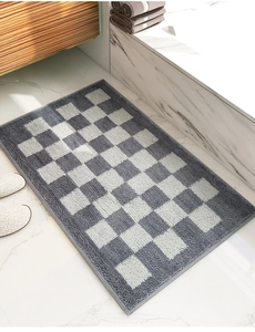 Gros plan du tapis de bain à damier en peluche douce sur sol en marbre blanc