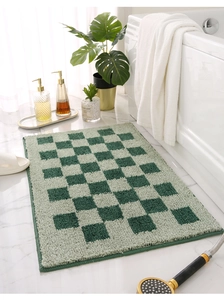 Détail de la texture d'un tapis de bain à carreaux verts sur un sol en marbre blanc