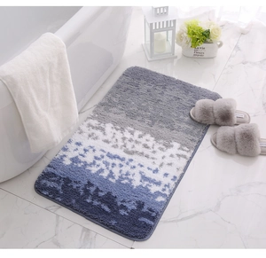 Detalle de alfombra de baño degradado azul de felpa con textura suave en suelo mármol