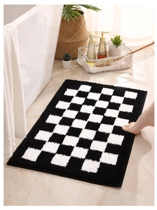 Close-up of thick checkerboard bath mat with absorbent plush texture near a bathtub