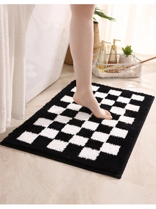 Detail of soft checkered bathroom mat texture with plush black and white fibers