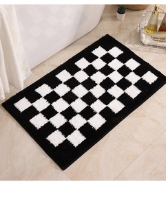 Detailed plush texture of checkered bathroom mat on tiled floor beside white bathtub