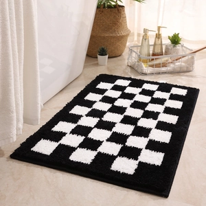 Classic checkered black and white bathroom mat with non-slip backing on marble floor