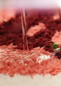 Close-up of thick absorbent bathroom mat with wavy red and pink plush flocking texture