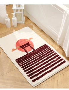 Detail of plush Japanese zen bath mat with red sun and torii gate silhouette