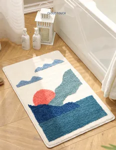 Detalle de alfombra de baño mullida con diseño minimalista de montañas azules y un sol
