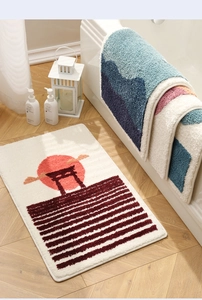 Detailed close-up of soft plush bathroom mat with sunrise and mountain art patterns
