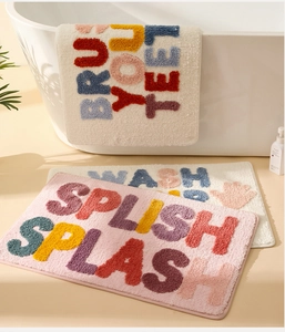 Detail of plush microfiber bath mat with vibrant 3D flocking letters on bathroom floor