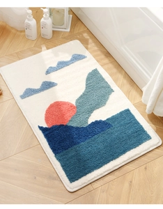 Detail of tufted bathroom mat with colorful sun and mountain landscape on wood floor