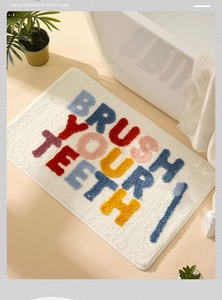 Detail of Brush Your Teeth absorbent bathroom mat with colorful letters and soft texture