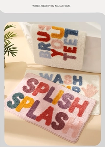 Close-up of plush tufted texture and slogan detail on water-absorbent bathroom rugs