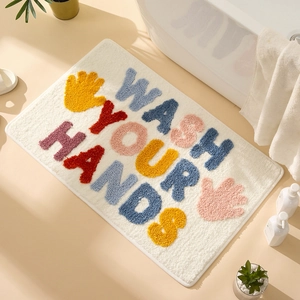 Plush rectangular bath mat with WASH YOUR HANDS slogan and colorful handprints