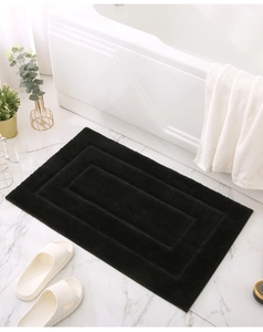 Macro shot of rectangular black bathroom mat with textured geometric pattern in bathroom