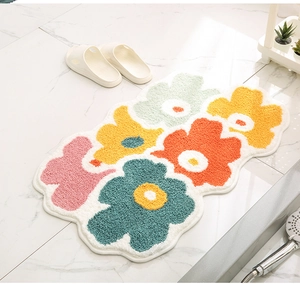 Close-up of colorful floral flocked bath mat with non-slip texture on marble floor