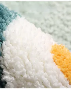 Macro detail of soft flocked bath mat with mint green, ivory, and yellow plush fibers