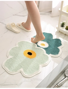Detail of high-density flocked floral bath mat with green petals and non-slip texture