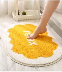 Close-up of soft absorbent oval bathroom mat with relax text and yellow egg design