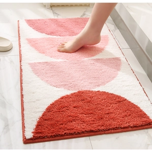 Detail showing thick absorbent texture of a pink geometric bath mat under step pressure