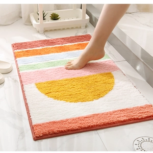 Detail of plush tufted bath mat featuring a colorful geometric pattern and water absorption