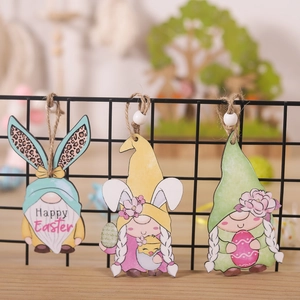 Three wooden Easter gnome ornaments with bunny ears and Happy Easter print hanging on rack