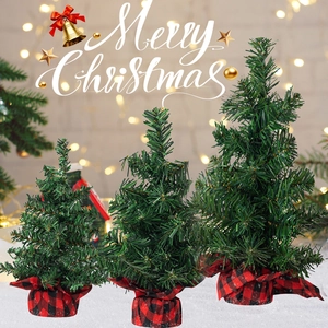 Three mini artificial Christmas trees in varied heights with red buffalo plaid fabric bases