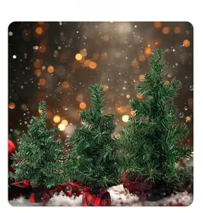 Three mini artificial Christmas trees with red and black plaid bases on snowy surface