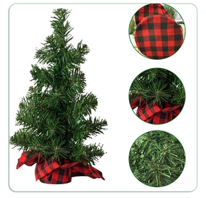 Macro details of mini artificial Christmas tree with red buffalo plaid fabric base