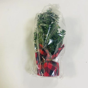 Mini artificial Christmas tree with red and black plaid base in protective packaging
