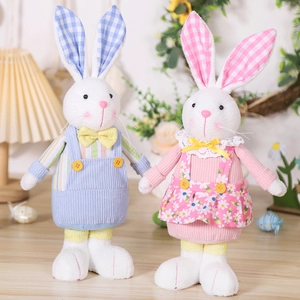 Detail of Easter bunny plush set in blue overalls and pink floral dress home decor