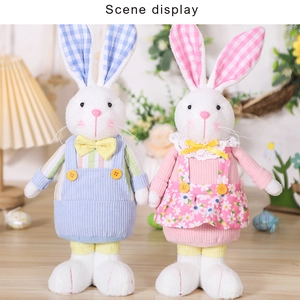 Detailed close-up of plush Easter bunnies in floral dress and striped overalls