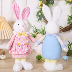 Detailed view of plush Easter bunnies in daisy dress and blue top on festive wooden table