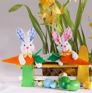 Easter plush rabbit pair with orange carrots and colorful eggs for festive decoration