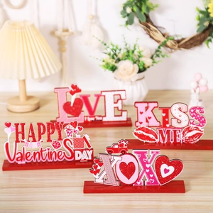 Detail of four festive Valentine's Day wooden table signs with Love and Kiss Me designs