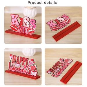 Close-up of Kiss Me and Happy Valentine's Day wooden tabletop signs with red slot bases