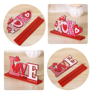Detail view of XOXO and LOVE wooden Valentine table signs with red glitter hearts