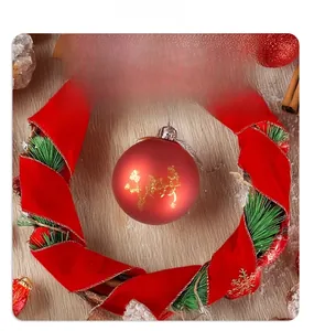 Close-up of red velvet Christmas wreath with Welcome sign and festive gold painted bauble