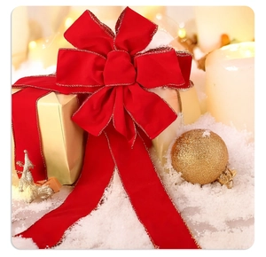 Red velvet Christmas bow with gold edges on a festive gift box decoration