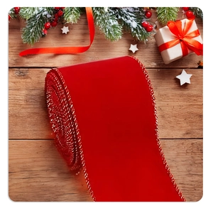 Detailed close-up of 6cm red velvet Christmas ribbon with gold wire edges on rustic wood