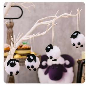 Detail view of four cute lamb ornaments hanging on a white branch for Eid home decoration