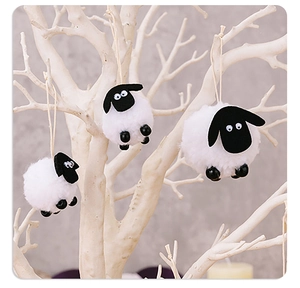 Three cute plush sheep ornaments with black beads hanging on a decorative branch