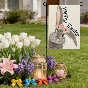 Easter bunny garden flag with Happy Easter text and floral wreath in a spring garden