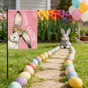 Close-up of Easter garden flag with Happy Easter text and bunny design in garden