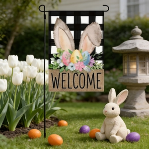 Close-up of Easter garden flag with bunny ears and colorful eggs in a spring yard