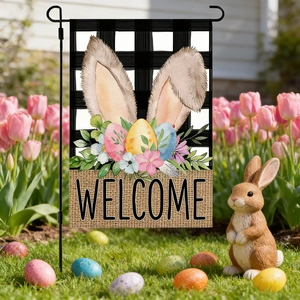 Detail of Easter garden flag with bunny ears and floral patterns in a spring yard