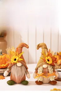 Detail of harvest gnome dolls with sunflowers and maple leaves on a cozy autumn desk