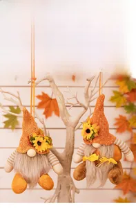 Close-up of autumn gnome ornaments with orange knit hats and maple leaf details