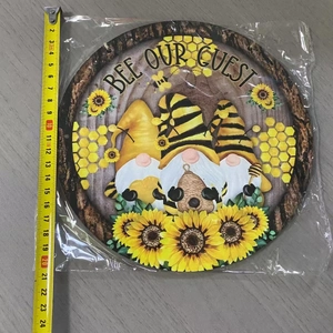 Detail shot of a 20cm Bee Our Guest gnome acrylic round plaque with a measuring tape