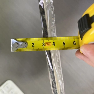 Detail showing measurement of 5mm thickness for floral wooden pendant using a tape measure