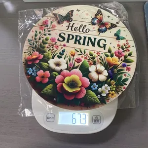 Detail showing round wooden spring sign on a digital scale weighing 67.3 grams