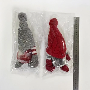 Detail von Weihnachtswichteln mit Strickmützen neben einem 37 cm langen Messlineal